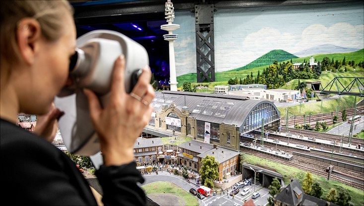 Besucherin guckt durch AR-Fernrohr im Miniatur Wunderland